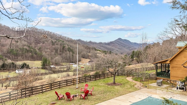 view of yard with a rural view, a patio, an outdoor fire pit, and a fenced backyard