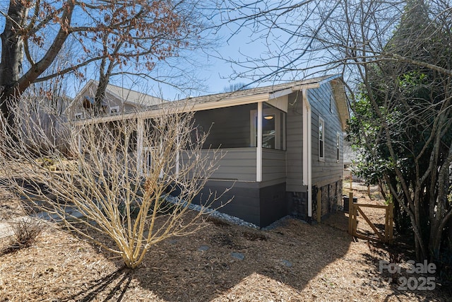 view of side of property with central AC and roof with shingles