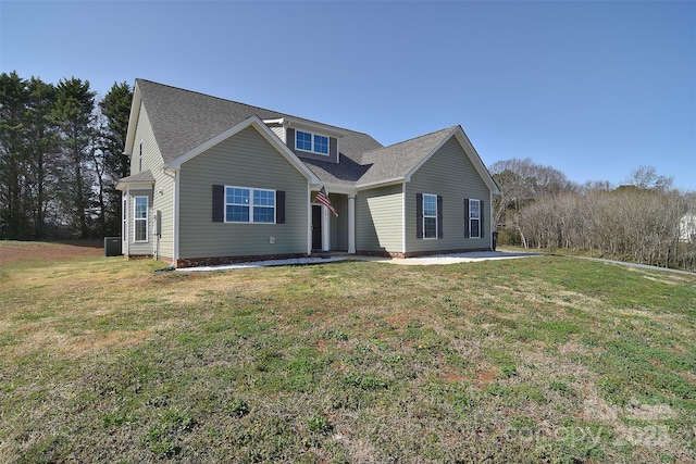 traditional home with roof with shingles and a front yard