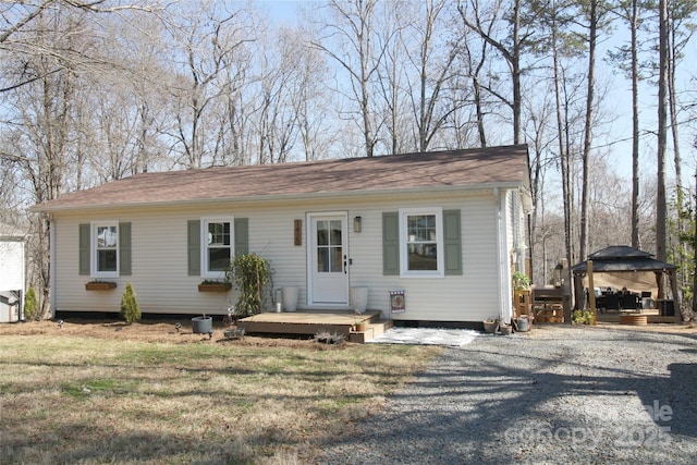 view of front facade with driveway, a wooden deck, a front yard, and a gazebo