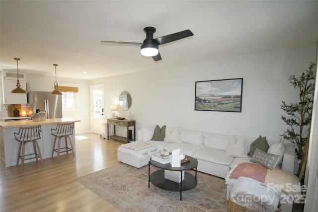 living area featuring ceiling fan and light wood finished floors