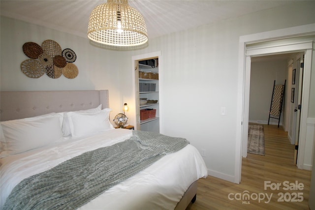 bedroom with baseboards and wood finished floors