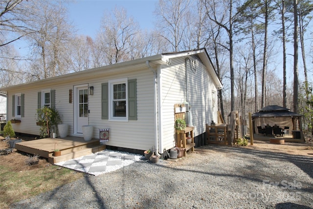 view of front of property featuring a deck and a gazebo