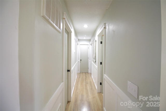 hallway featuring visible vents and light wood-style flooring