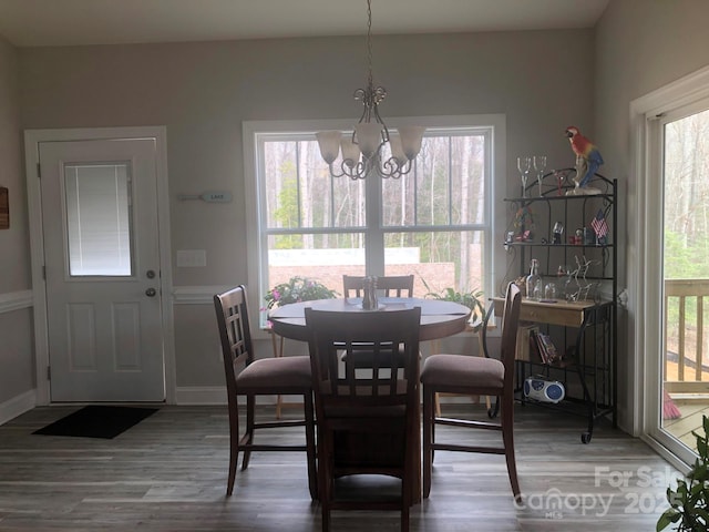 dining area with a notable chandelier, baseboards, and wood finished floors