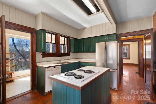 kitchen with white appliances, dark wood-type flooring, a sink, light countertops, and green cabinetry