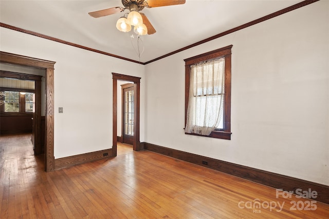 empty room featuring ornamental molding, baseboards, ceiling fan, and hardwood / wood-style floors