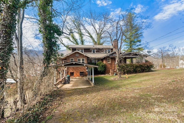 view of front of house featuring a front yard, a patio, and a chimney