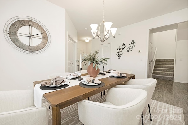 dining space featuring an inviting chandelier, stairs, and wood finished floors