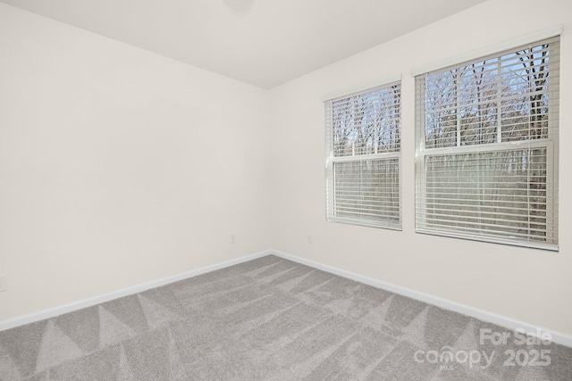 empty room featuring carpet and baseboards