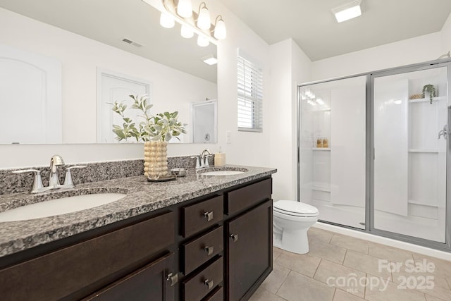 bathroom with toilet, a stall shower, a sink, and visible vents