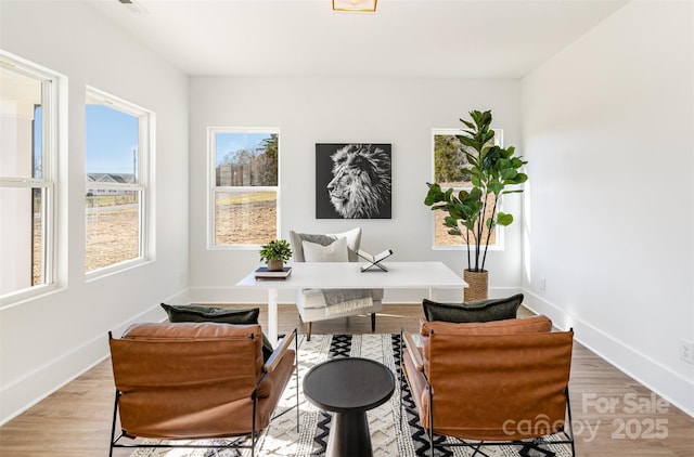 living area with light wood-style flooring and baseboards