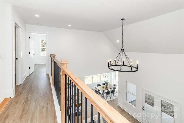 hall featuring recessed lighting, an upstairs landing, baseboards, vaulted ceiling, and light wood-type flooring