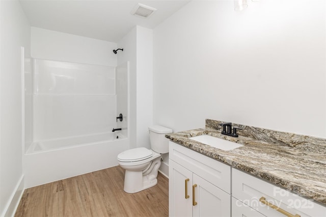 bathroom with shower / bath combination, visible vents, toilet, wood finished floors, and vanity