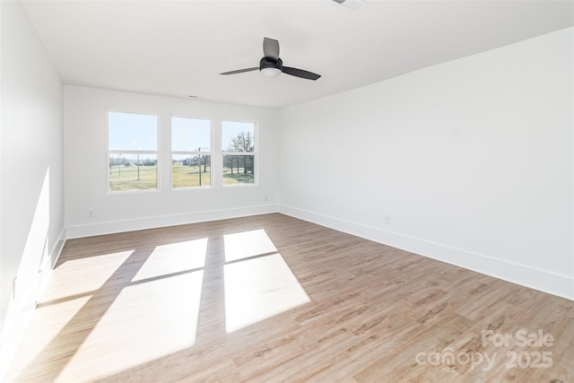 unfurnished room featuring a ceiling fan, baseboards, and wood finished floors