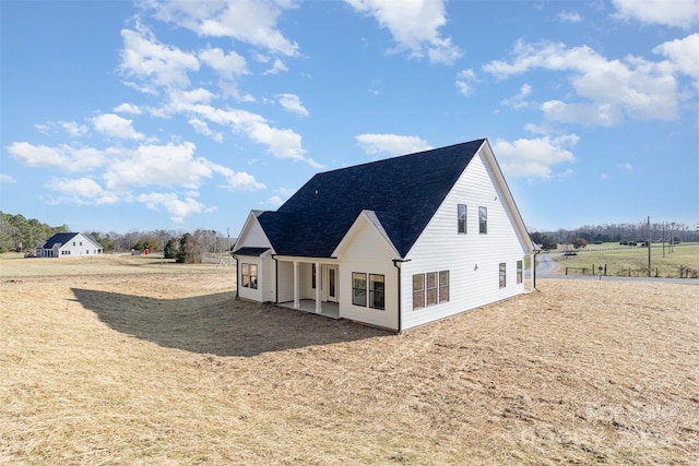 view of home's exterior featuring roof with shingles and a patio area