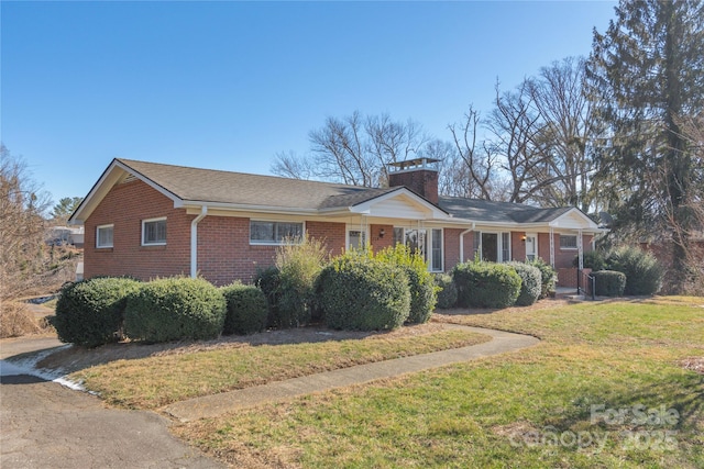 ranch-style home with a front lawn, a chimney, and brick siding