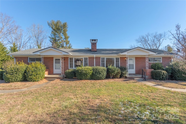 ranch-style home featuring a front yard, brick siding, and a chimney