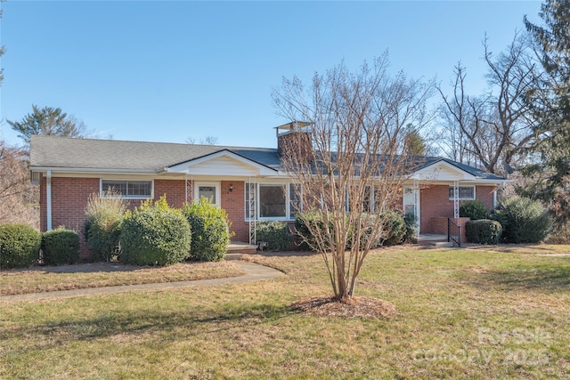 ranch-style home with covered porch, brick siding, a chimney, and a front yard