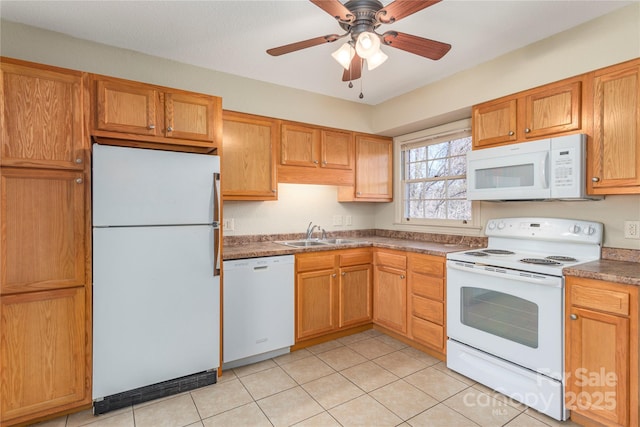 kitchen featuring light tile patterned floors, white appliances, a sink, a ceiling fan, and dark countertops