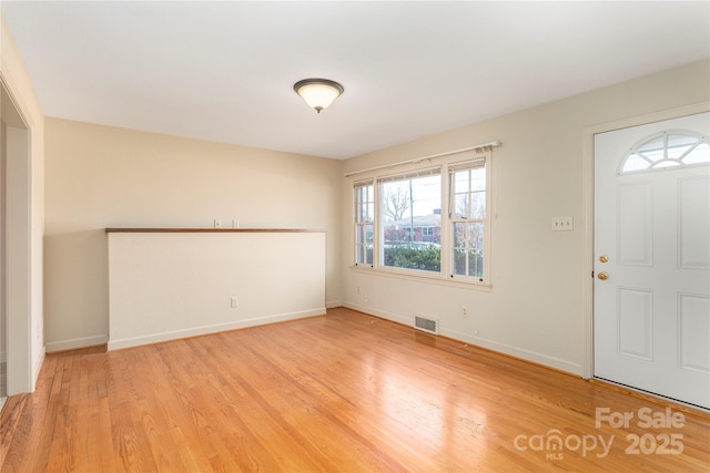 foyer entrance with light wood-style floors, visible vents, and baseboards