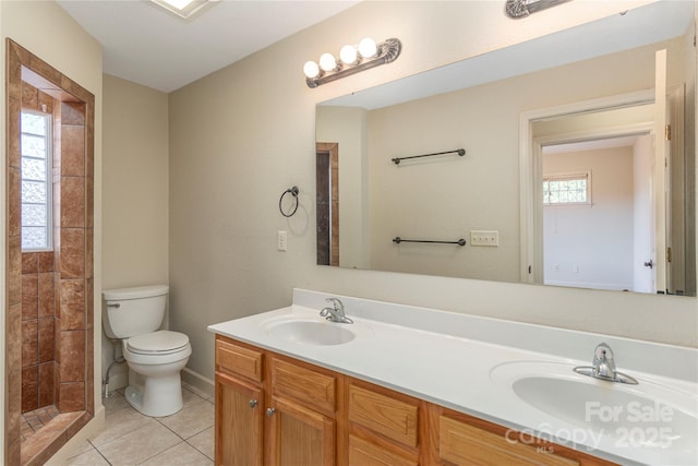 full bath with double vanity, tile patterned flooring, a sink, and toilet