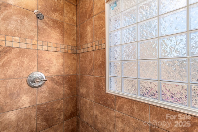 interior details featuring a tile shower