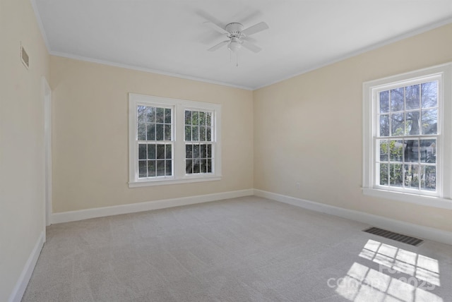 empty room featuring ornamental molding, visible vents, light carpet, and baseboards