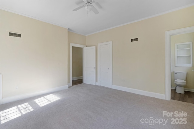 unfurnished bedroom with ornamental molding, baseboards, visible vents, and carpet flooring