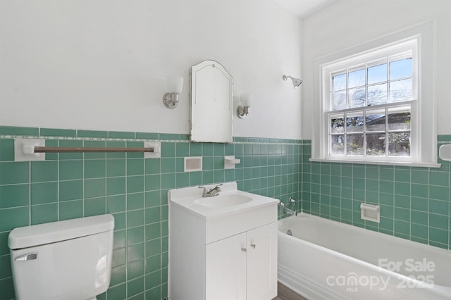 full bath with a tub to relax in, toilet, a wainscoted wall, vanity, and tile walls