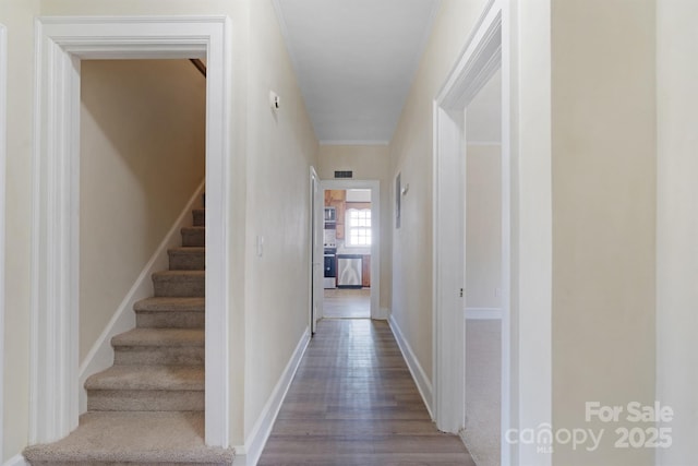 hall featuring visible vents, stairway, baseboards, and wood finished floors