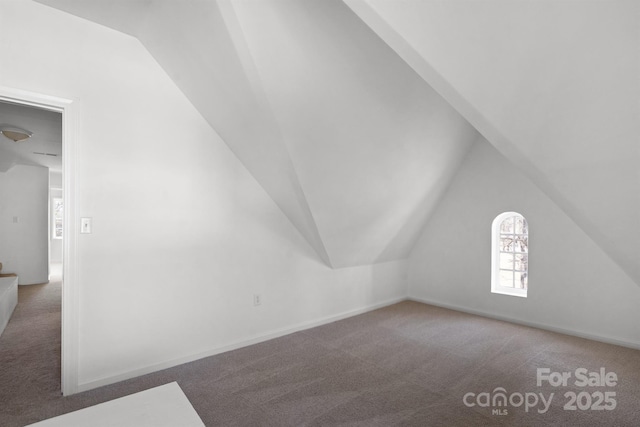 bonus room featuring lofted ceiling, carpet flooring, and baseboards