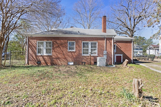 view of side of home featuring crawl space, fence, a lawn, and brick siding