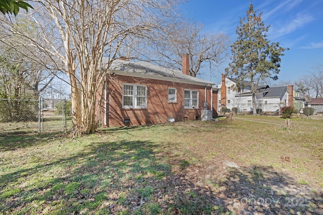 exterior space with brick siding, a chimney, crawl space, fence, and a front lawn