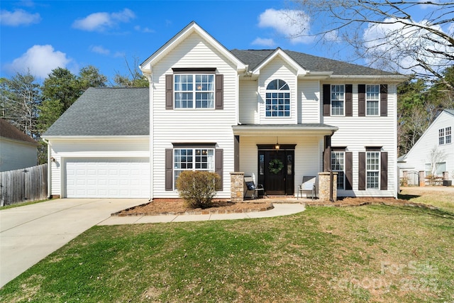 colonial inspired home with driveway, a garage, a shingled roof, fence, and a front lawn