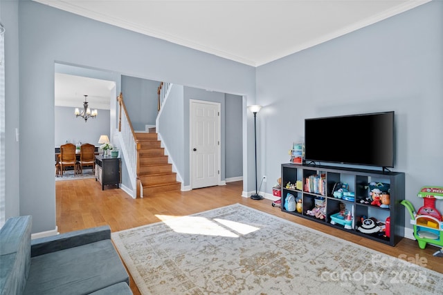 living area featuring crown molding, stairway, an inviting chandelier, wood finished floors, and baseboards