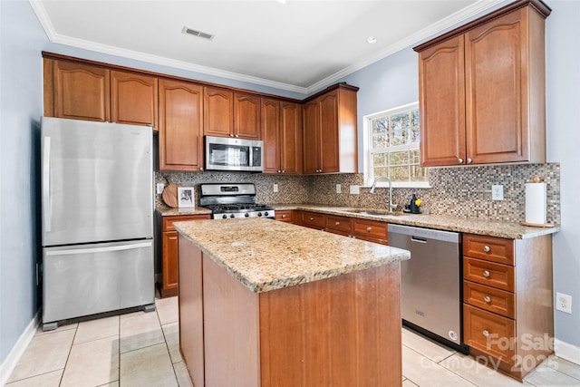 kitchen featuring stainless steel appliances, a sink, light stone counters, and tasteful backsplash