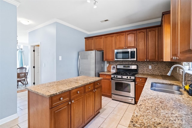 kitchen featuring tasteful backsplash, visible vents, appliances with stainless steel finishes, a sink, and light stone countertops