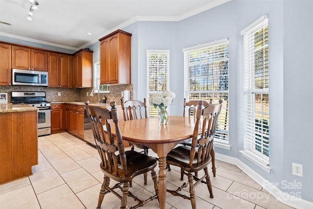 kitchen featuring brown cabinets, stainless steel appliances, decorative backsplash, and light tile patterned flooring