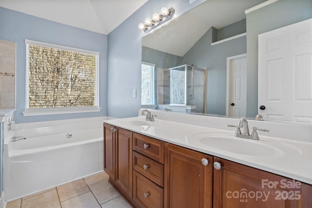 full bath with lofted ceiling, a shower stall, a sink, and tile patterned floors