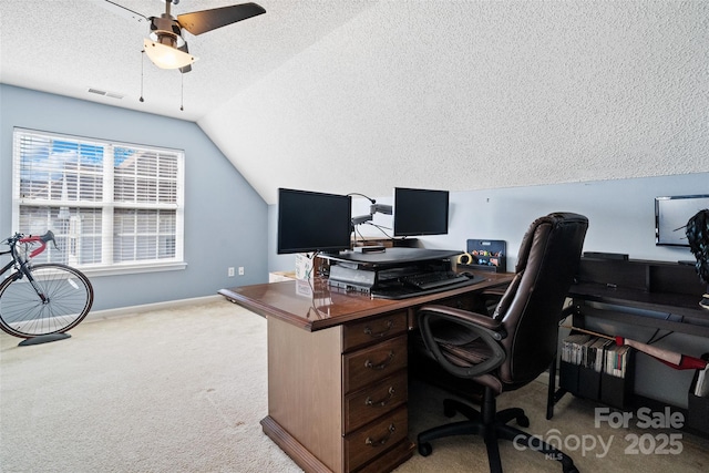 carpeted office featuring lofted ceiling, visible vents, a ceiling fan, a textured ceiling, and baseboards