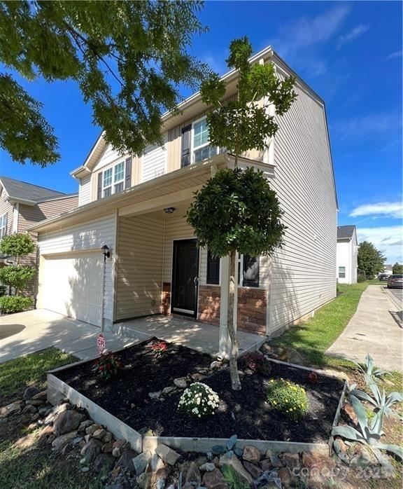 view of front of property featuring driveway, covered porch, and a garage