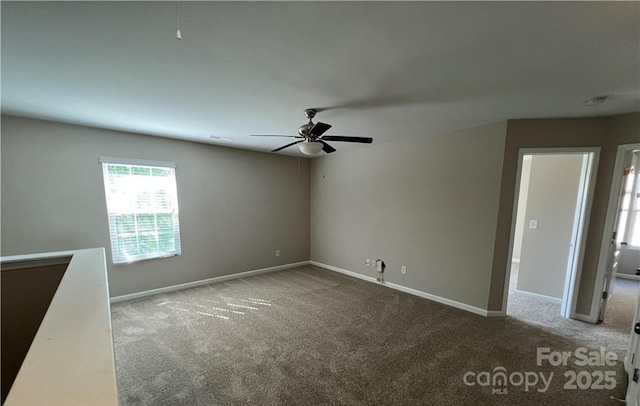 spare room featuring ceiling fan, carpet flooring, and baseboards