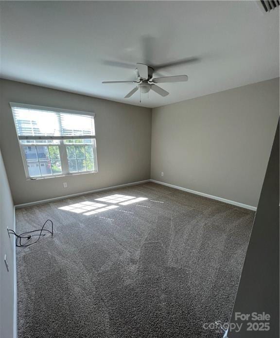 carpeted empty room with visible vents, baseboards, and a ceiling fan