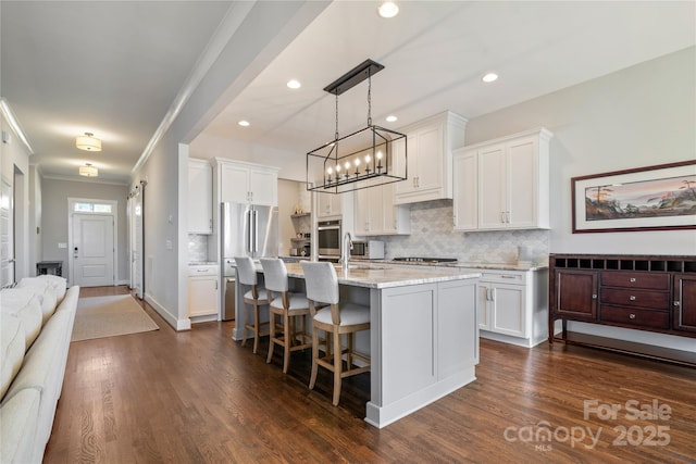 kitchen featuring dark wood-style floors, appliances with stainless steel finishes, a sink, and white cabinetry