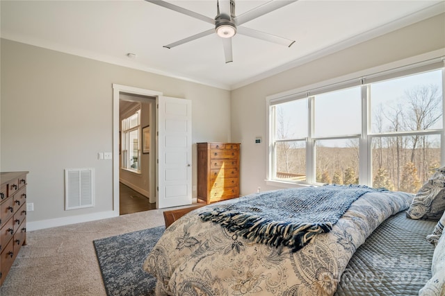 carpeted bedroom featuring baseboards, visible vents, ceiling fan, and ornamental molding