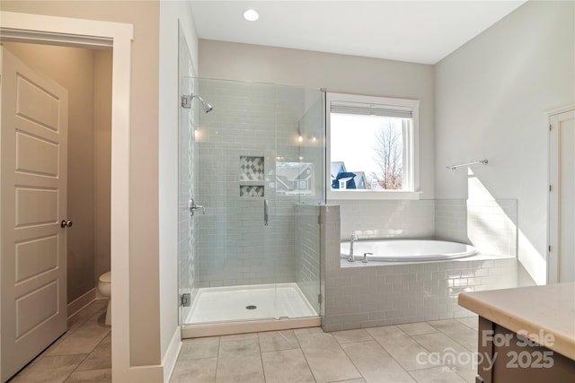 bathroom featuring toilet, a stall shower, tile patterned flooring, and a garden tub