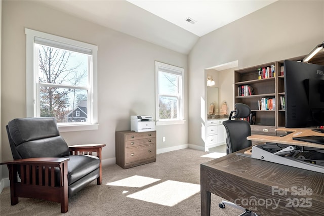 office area with vaulted ceiling, baseboards, visible vents, and light colored carpet