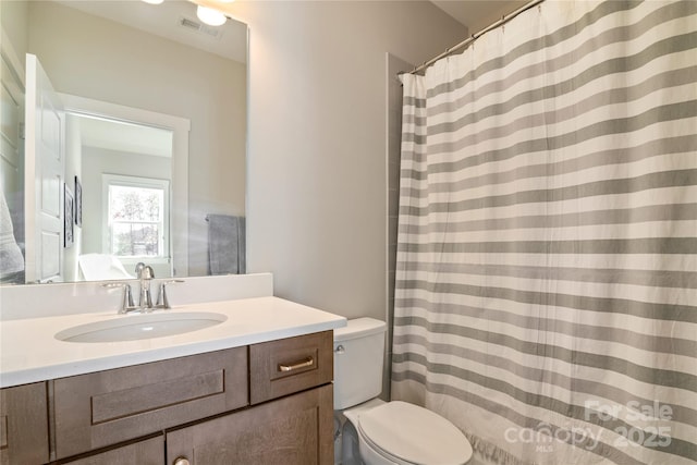 full bathroom with toilet, visible vents, and vanity