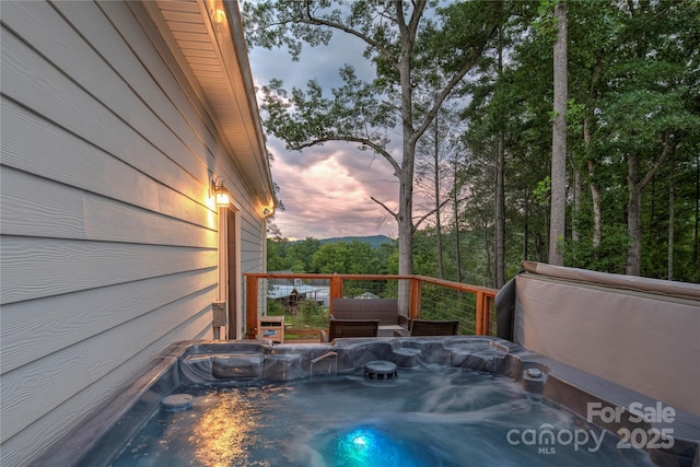 deck at dusk with a hot tub